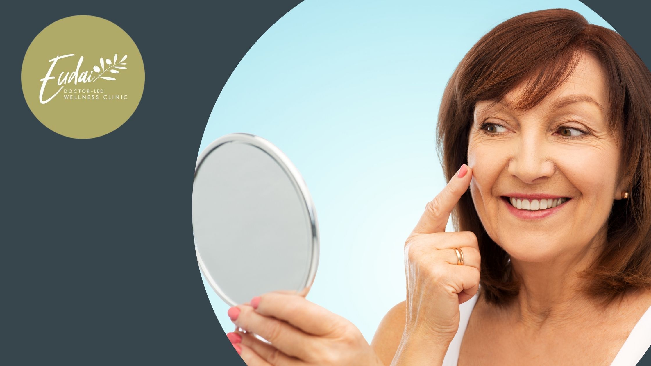 A cheerful mature woman with brown hair examining her glowing skin in a handheld mirror, symbolizing the confidence-boosting results offered by Eudai Wellness Clinic's treatments.